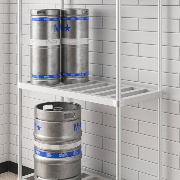 A Regency metal shelf for beer kegs with barrels and cans on it.