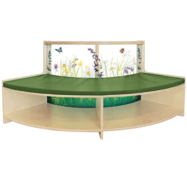 A wooden shelf with a green cushion with flowers and butterflies on it.