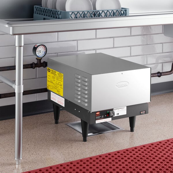 A compact stainless steel Hatco C-36 booster water heater installed under a commercial kitchen sink.