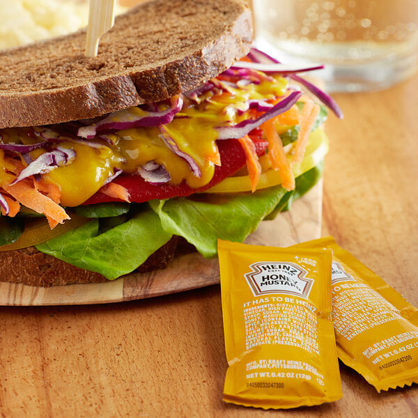 A sandwich with Heinz honey mustard on a table in a deli.