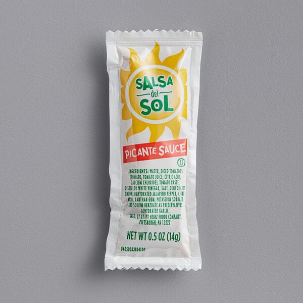 A white Salsa Del Sol single serve picante sauce packet with a yellow sun design.