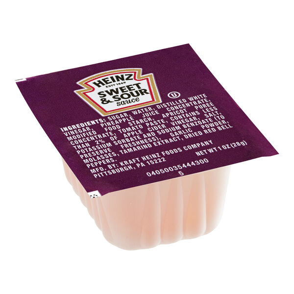 A single-serve Heinz sweet and sour sauce portion cup with a purple foil lid.