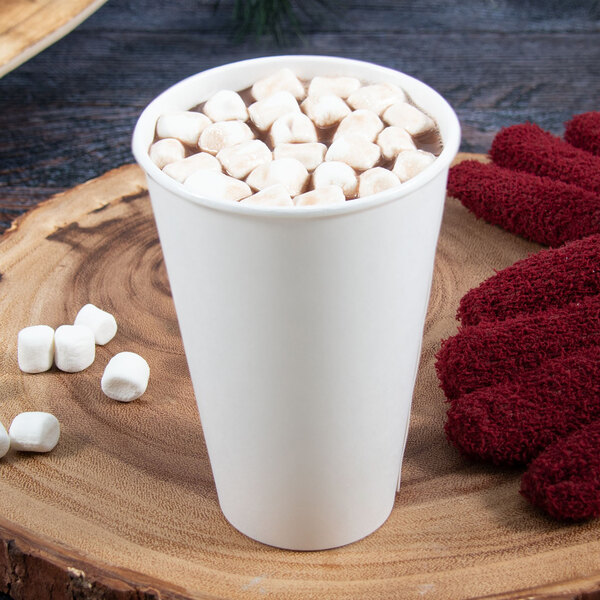 A Dart ThermoGuard white paper hot cup of hot chocolate with marshmallows and a red fuzzy glove.