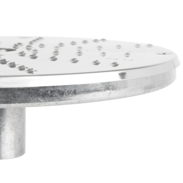 A Robot Coupe 1/16" grating/shredding disc, a circular metal surface with holes.