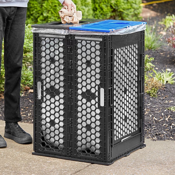 A man standing next to a Cerobin Collapsible dual-stream trash can with a bag in it.