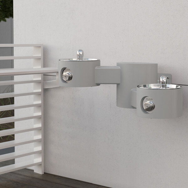 An Elkay gray outdoor wall mounted bi-level water fountain.