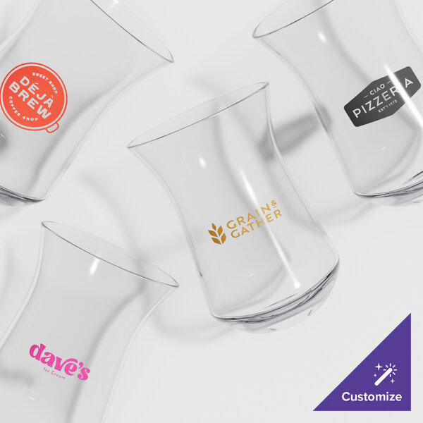 A close-up of a clear Via Tritan plastic mixing glass with pink text.