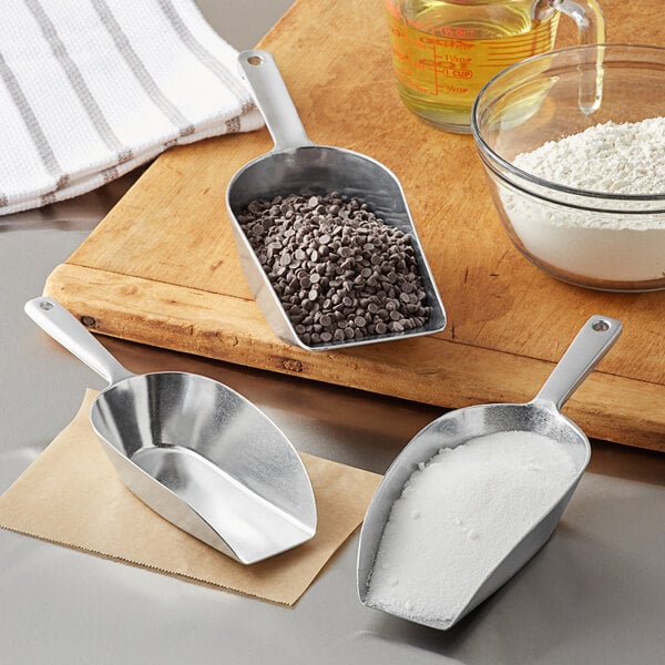 A Choice aluminum flat bottom scoop with a white powder.