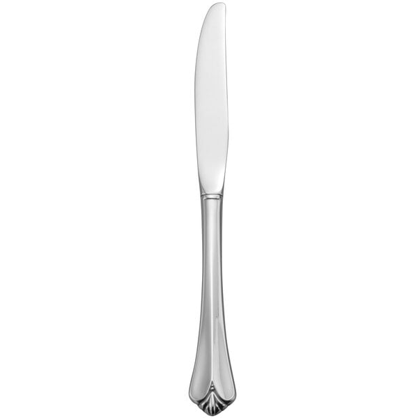 A close-up of a Oneida stainless steel dinner knife with a long blade and long handle.