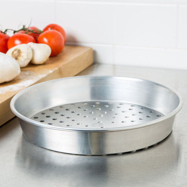 An American Metalcraft heavy weight aluminum pizza pan with holes.