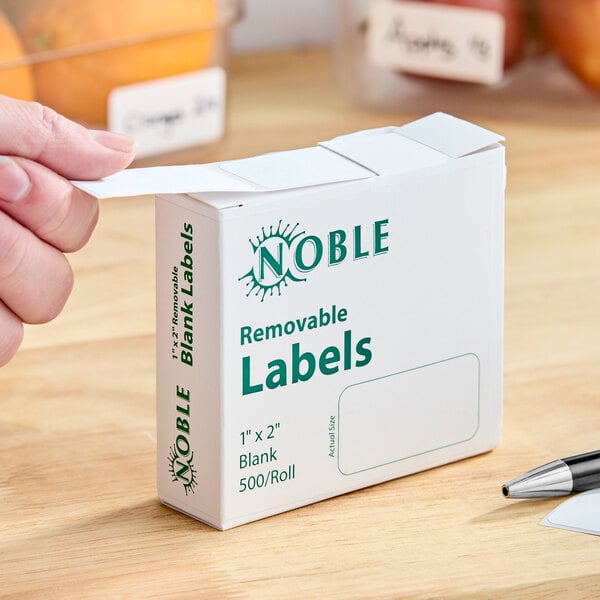 A box of Noble 1" x 2" removable blank labels containing 500 labels per roll.
