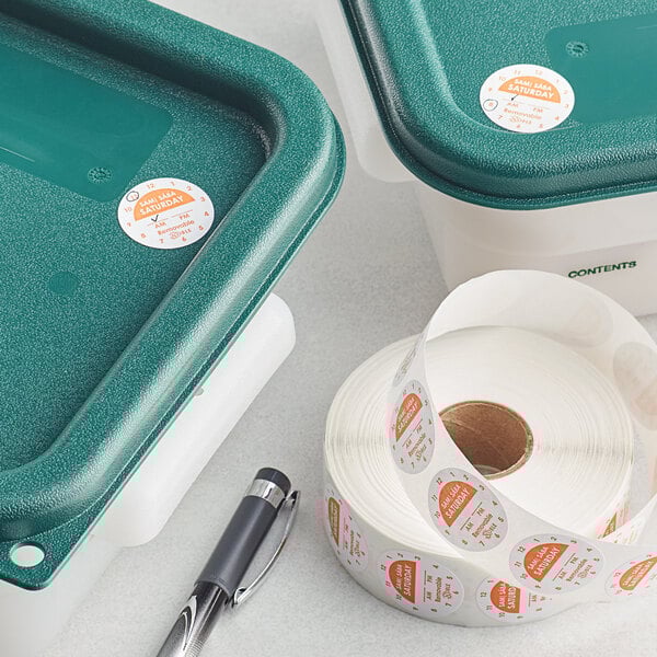 A roll of Noble Products green and white Saturday 1" clock labels on a countertop.