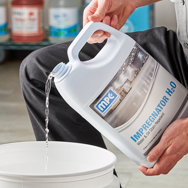 A person pouring liquid from a bottle into a container.