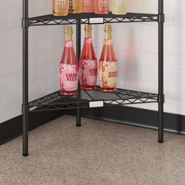 A Regency black epoxy triangle shelf with bottles of wine and liquor on it.