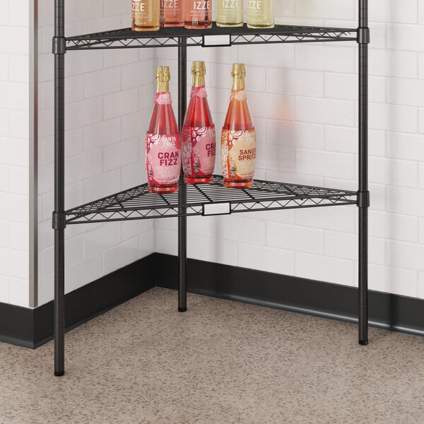 A Regency black metal triangle shelf with bottles of liquid on it.