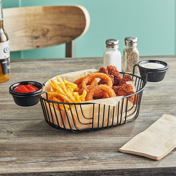 An Acopa oblong black wire basket with fried food on a table.