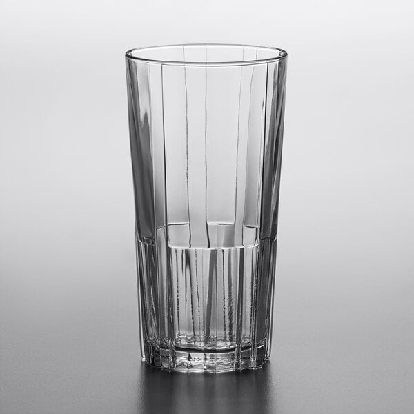A clear Duralex highball glass with a clear liquid inside.