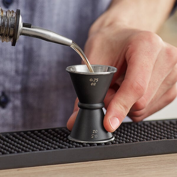 a person pouring liquid into a measuring cup