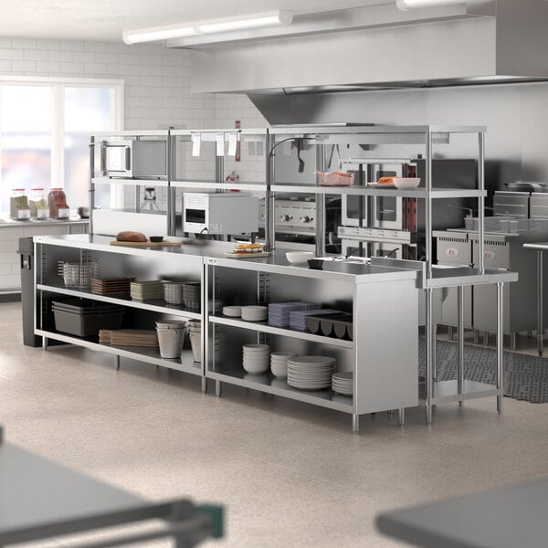 A Chef's Counter stainless steel work table with shelves and white rectangular dishes.