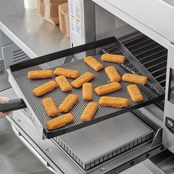 A piece of fried fish on a Baker's Mark black mesh surface.