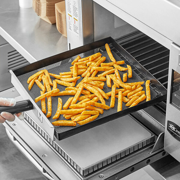 A person holding a Baker's Mark mesh basket filled with french fries.