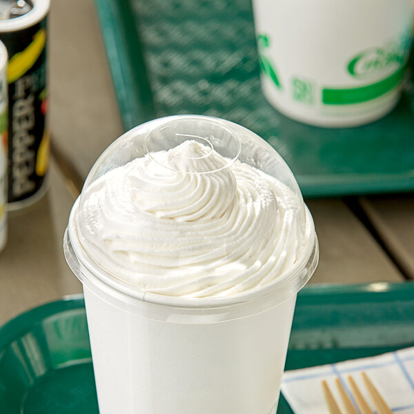 A white plastic cup of frozen yogurt with a white EcoChoice translucent dome lid with whipped cream inside.