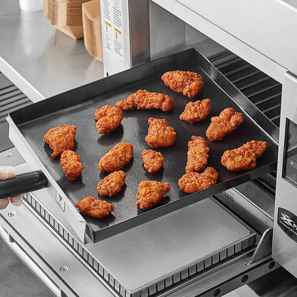 A person holding a Baker's Mark solid non-stick pan with fried food on it.