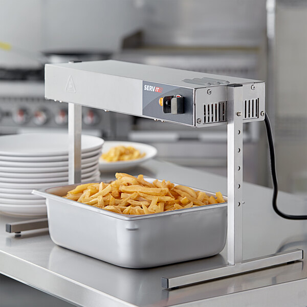 A ServIt strip warmer on a table over a bowl of food.