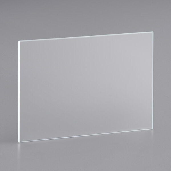 A clear rectangular glass shelf on a gray surface.