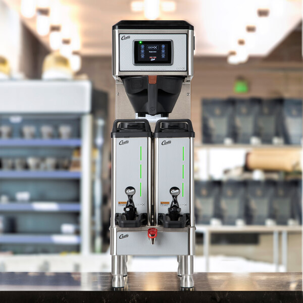 A commercial twin coffee brewer with two insulated servers and a digital control panel.