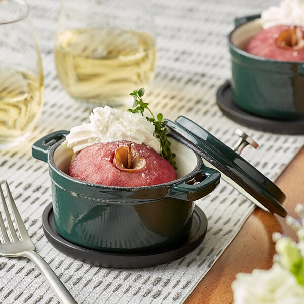 Two green Valor enameled cast iron pots with covers filled with food on a table.