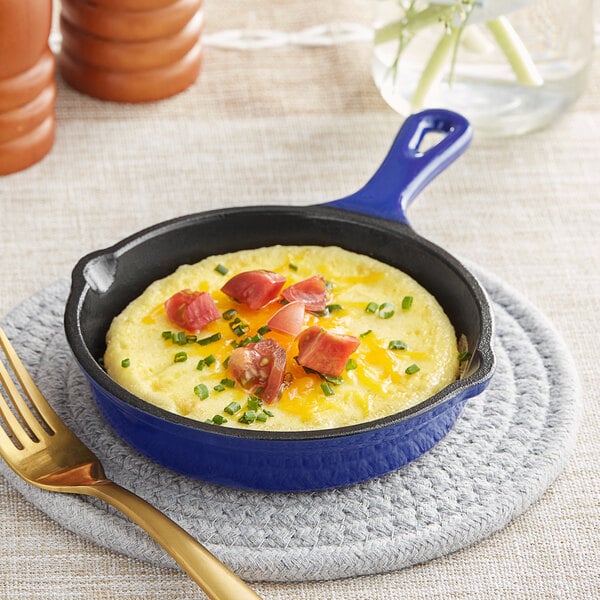 A Valor Galaxy Blue enameled cast iron skillet with a mini omelette with bacon and chives.