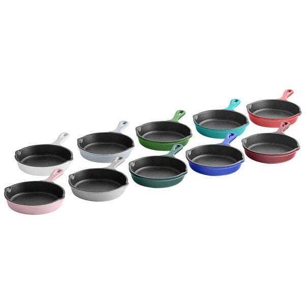A row of Valor 5" Glacier enameled mini cast iron skillets with different colors inside.