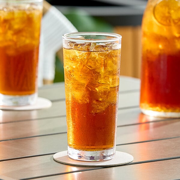 A glass of DominAde iced tea on a table with ice.