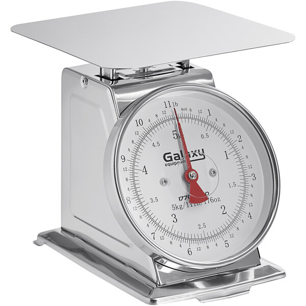 A close-up of a silver Galaxy mechanical portion scale with a red hand and white dial.