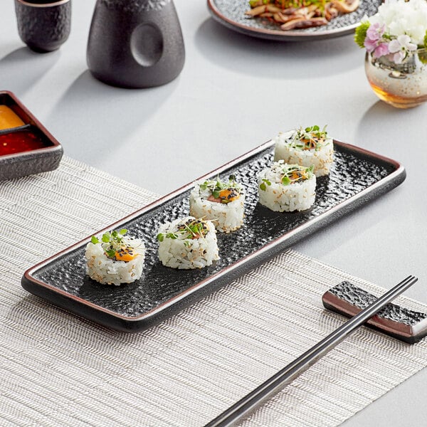 Sushi presentation on a sushi plate next to chopsticks