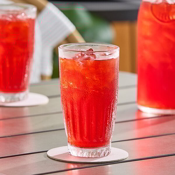 A glass of DominAde Fruit Punch on a table.