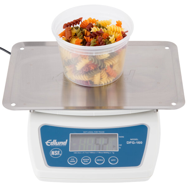 An Edlund digital portion scale with a bowl of pasta on it.