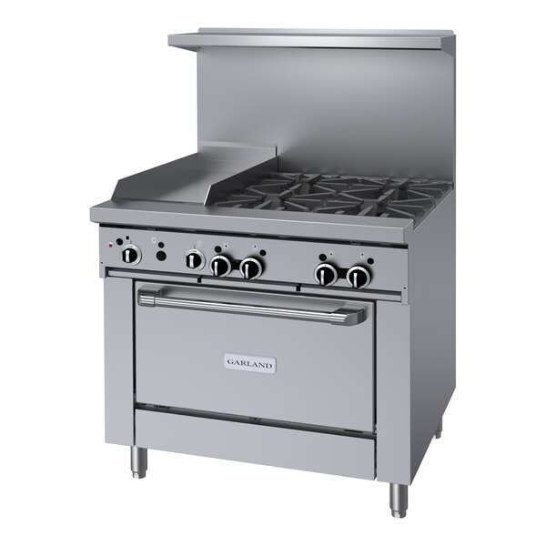 A stainless steel Garland commercial gas range with four burners, knobs, and a griddle over the burners.