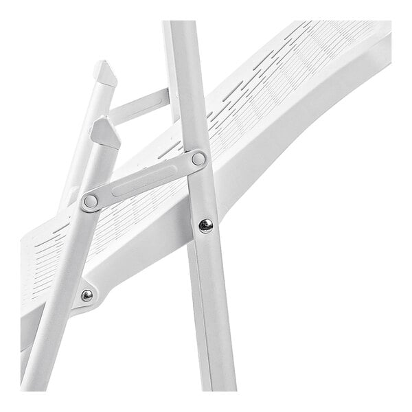 A close-up view of the white metal frame and hinge mechanism of a folding chair.