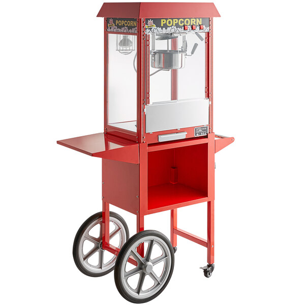 A red Carnival King popcorn cart with a popcorn machine on it.