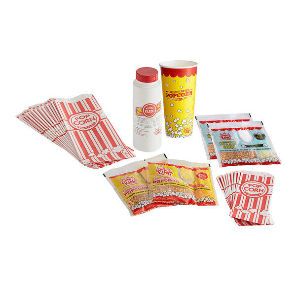 A stack of red and white Carnival King popcorn bags with a couple of bags of popcorn.