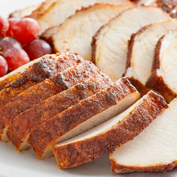 Sliced turkey seasoned with Lawry's Memphis BBQ Rub on a plate with grapes.