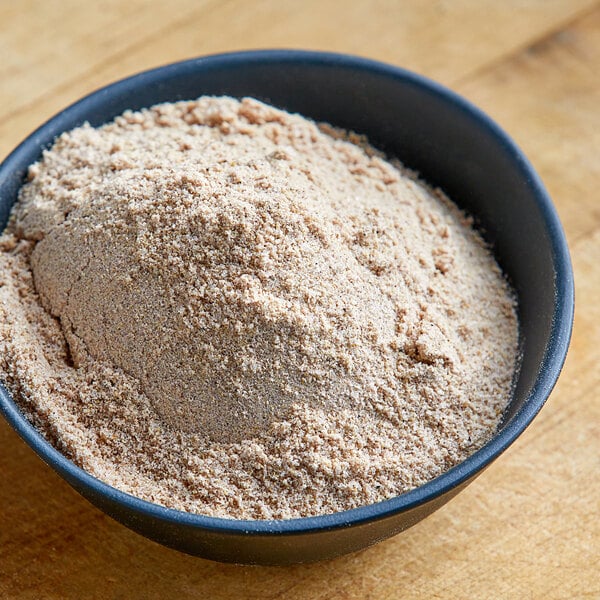 A bowl of Lawry's Spatini spaghetti seasoning mix on a wooden table.