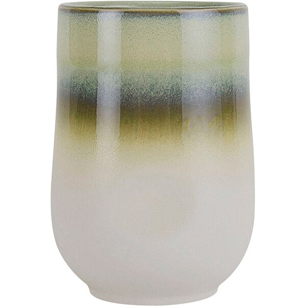 A close-up of a white and green Tuxton China cocktail tumbler with a green and white stripe.