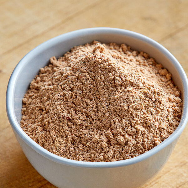 A bowl of Lawry's Fajitas seasoning mix on a wooden table.