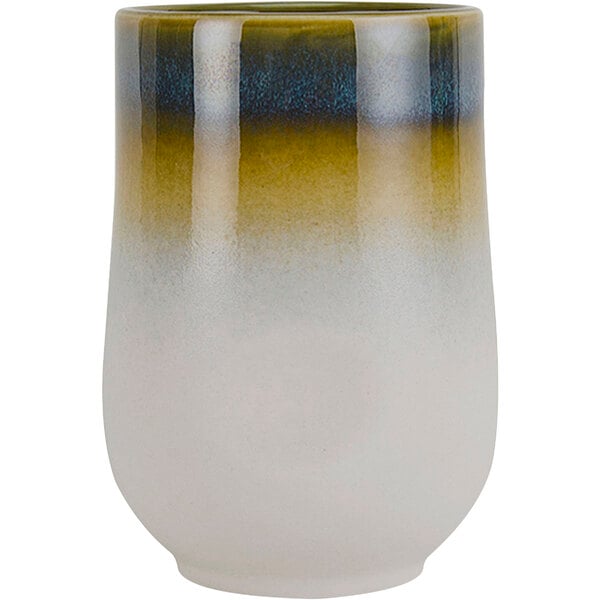A close-up of a white cup with a green and blue ombre surface.