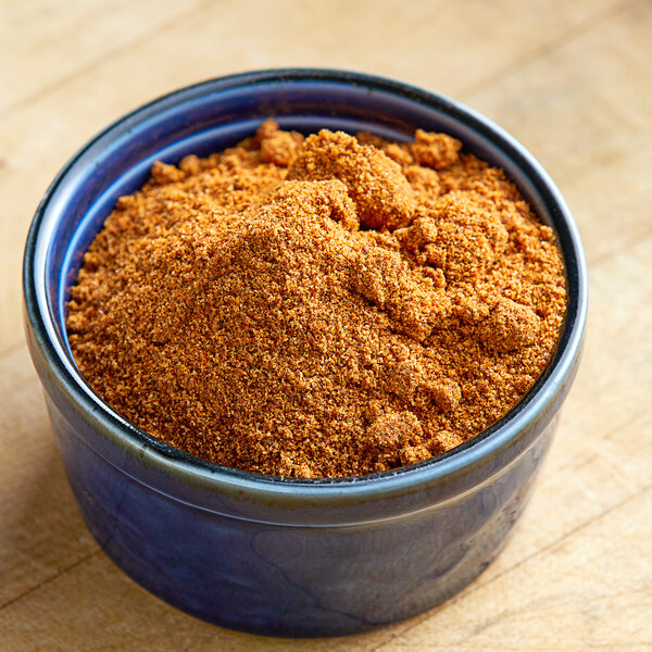 A bowl of Lawry's Pit BBQ seasoning on a wooden table.