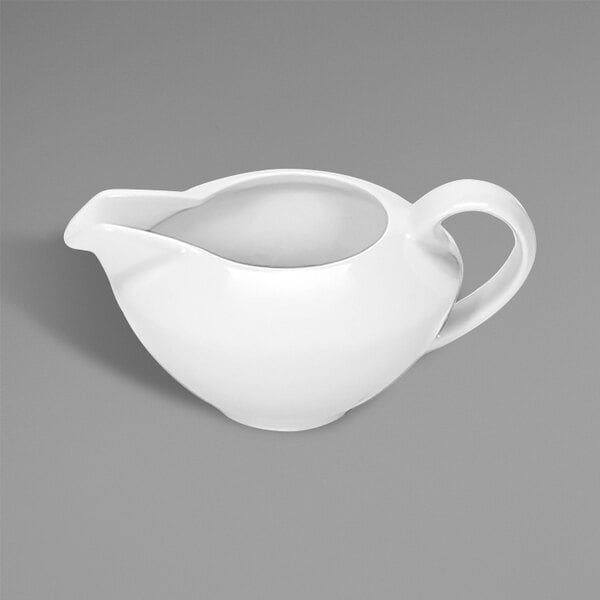 A white ceramic sauce pot with a white handle.