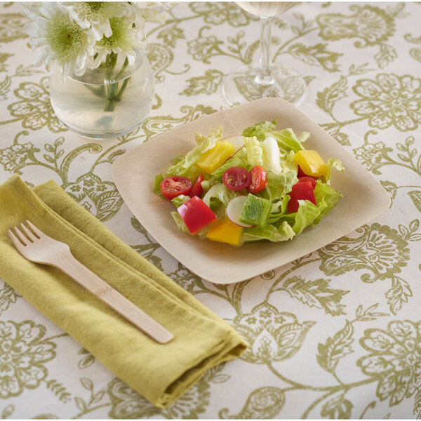 A Bambu Veneerware plate with a salad and a fork on a table.